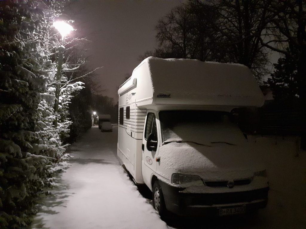 Wohnmobil im Schnee unter Straßenlampe